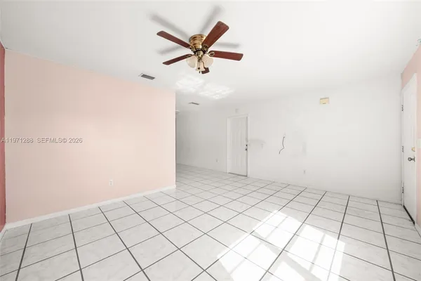 an empty room with windows and fan