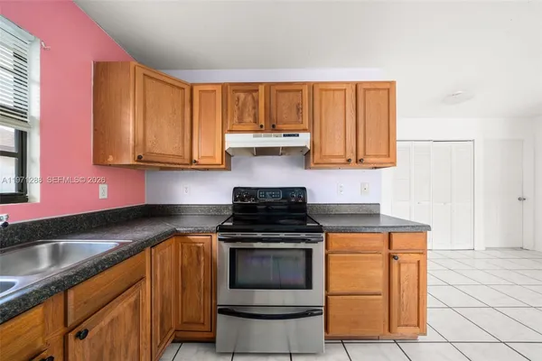 a kitchen with stainless steel appliances granite countertop a stove a sink and a refrigerator
