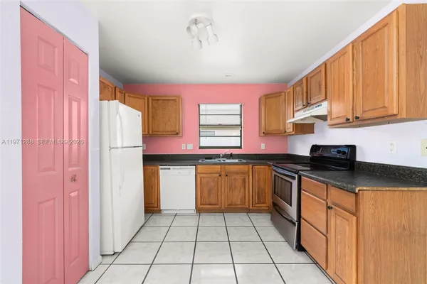 a kitchen with granite countertop a sink cabinets and stainless steel appliances