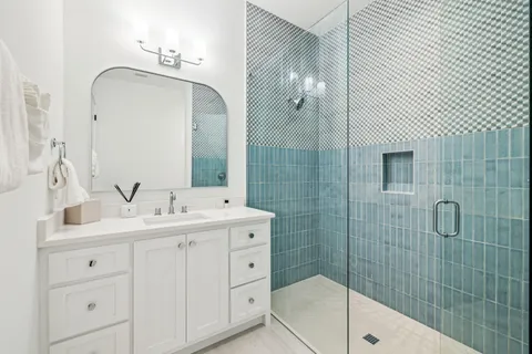 a bathroom with a double vanity sink mirror and shower