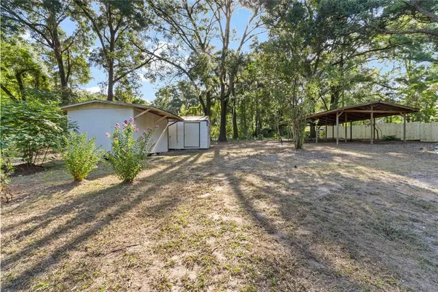 a view of wooden house with a yard