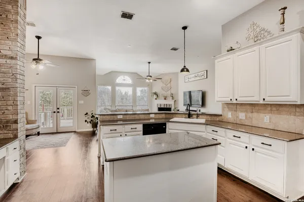 a kitchen with stainless steel appliances granite countertop a sink a stove and a refrigerator