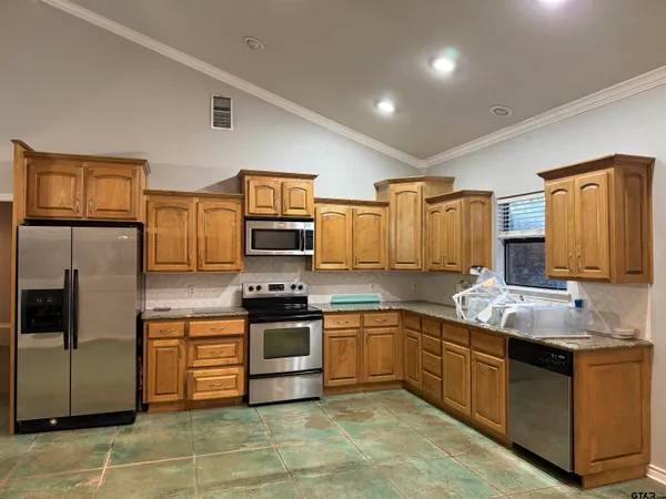 a kitchen with stainless steel appliances granite countertop a sink stove and refrigerator