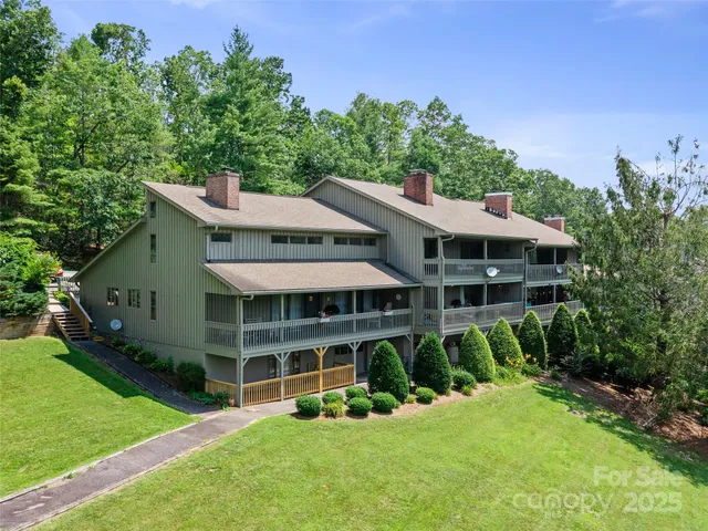 a view of a house with a yard and potted plants