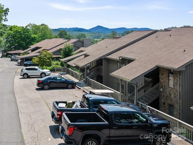 a view of multiple houses with cars parked