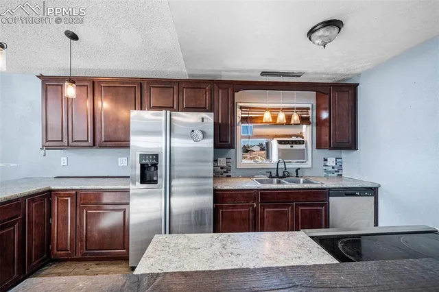a kitchen with kitchen island granite countertop wooden cabinets a sink and stainless steel appliances