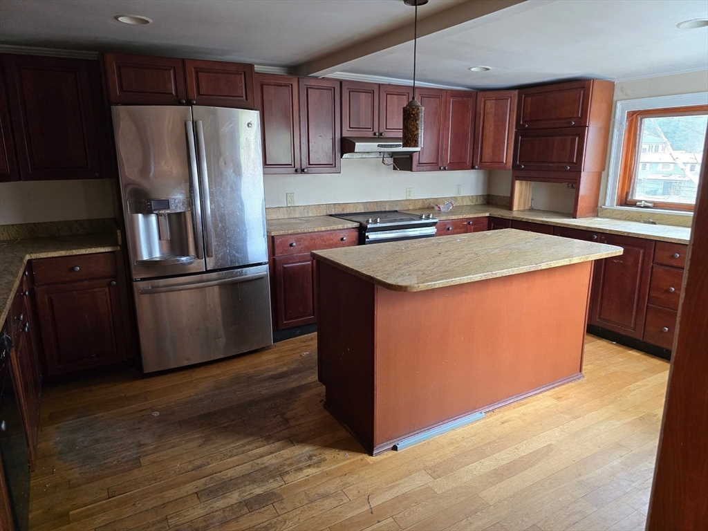 115 East Road Westminster, MA 01473 - Photo 4 of 15 a kitchen with kitchen island a sink refrigerator and wooden cabinets