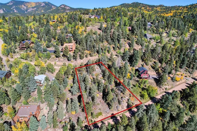 an aerial view of residential houses with street and trees