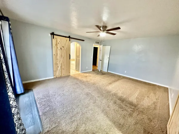a view of a big room with closet and a ceiling fan