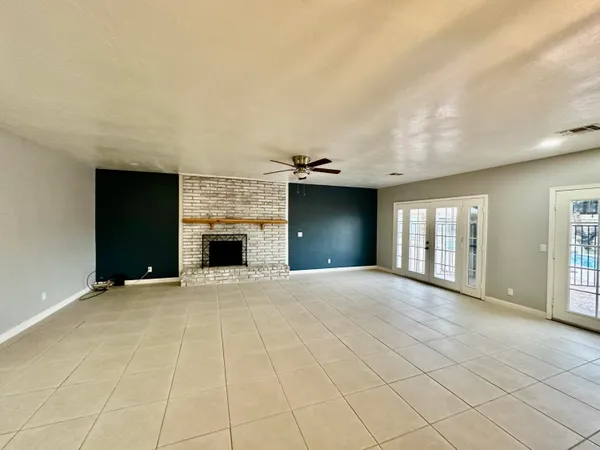 a view of an empty room with a fireplace and a window