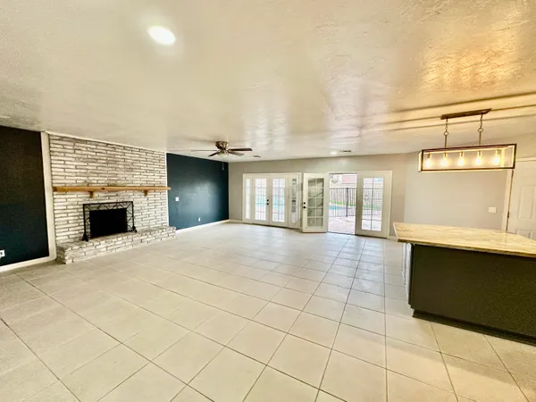 a view of an empty room with a fireplace and a window