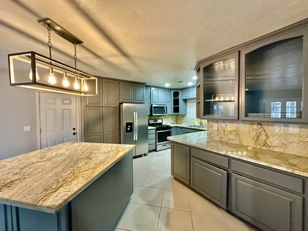 a kitchen with refrigerator and chairs