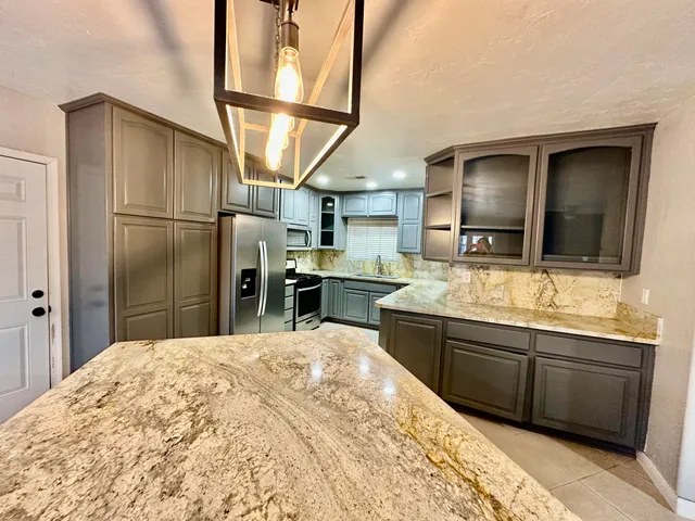 a kitchen with stainless steel appliances granite countertop a sink stove and refrigerator