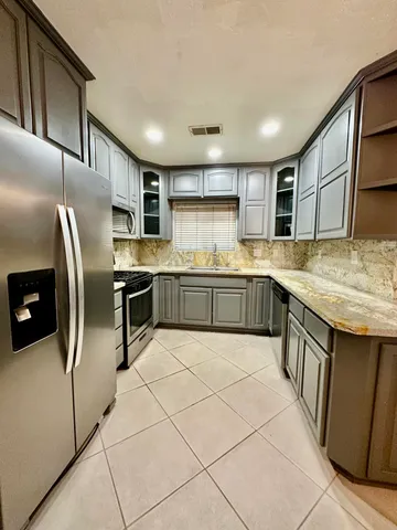 a kitchen with granite countertop cabinets stainless steel appliances and wooden cabinets