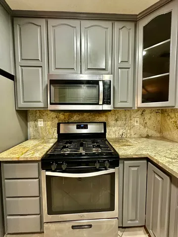 a kitchen with stainless steel appliances granite countertop a refrigerator and a stove top oven