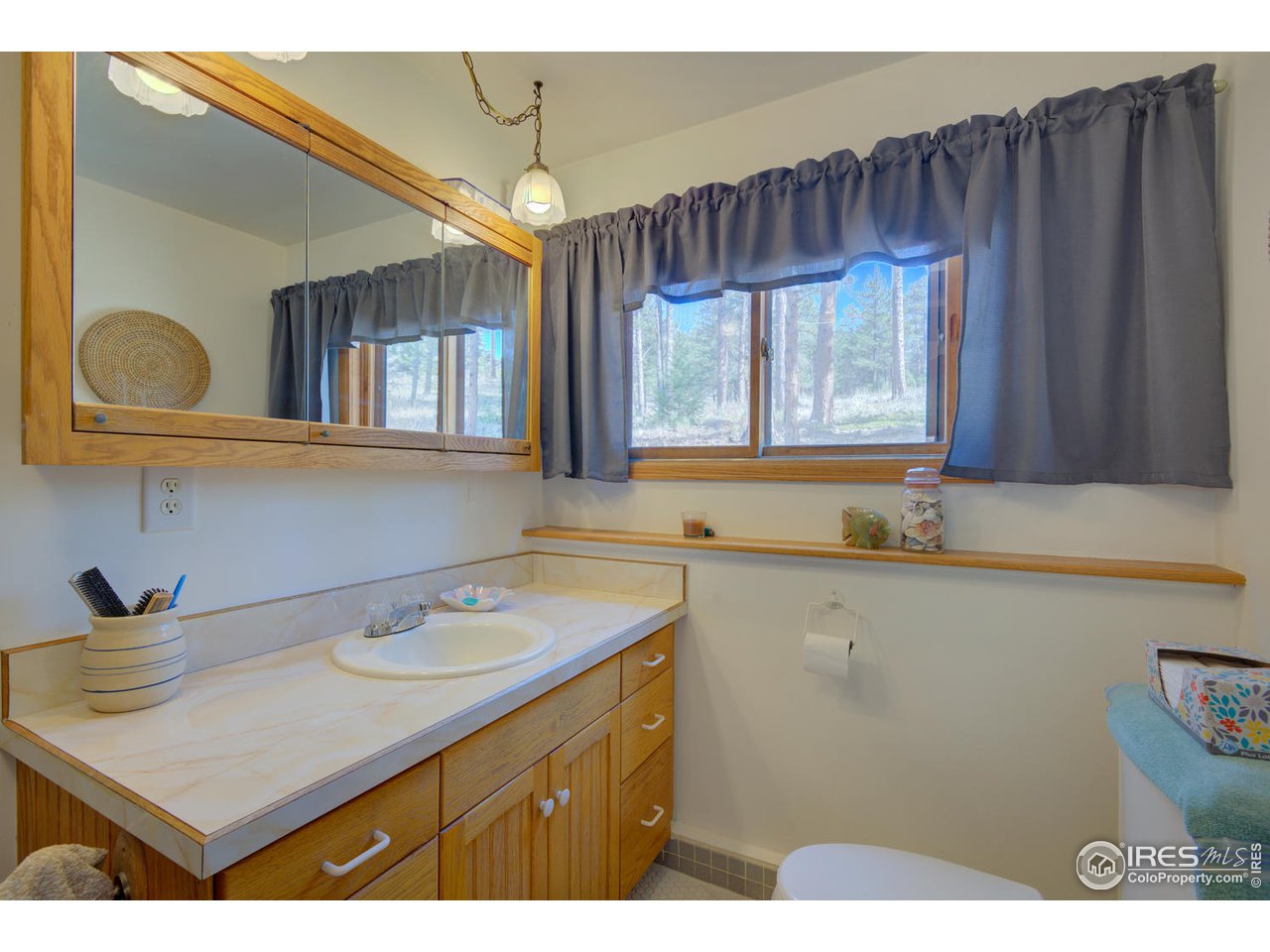 900 Spruce Drive Lyons, CO 80540 - Photo 17 of 40 a bathroom with a sink a vanity and a large mirror
