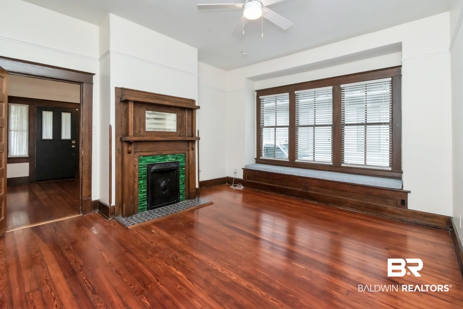 14 Kenneth Street Mobile, AL 36607 - Photo 4 of 32 Unfurnished living room with dark wood-type flooring, a tiled fireplace, and ceiling fan