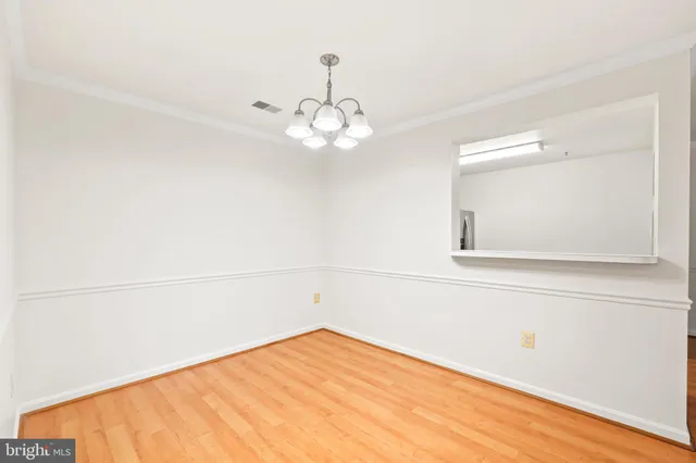 a view of a room with wooden floor and ceiling fan