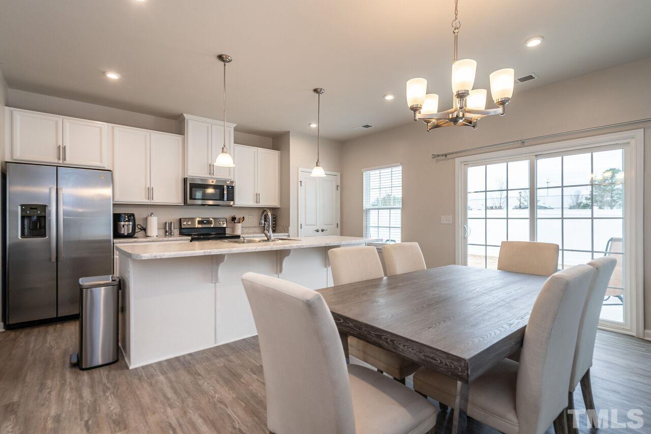 8701 Red Canyon Way Raleigh, NC 27616 - Photo 17 of 28 a view of a dining room with furniture a chandelier and wooden floor