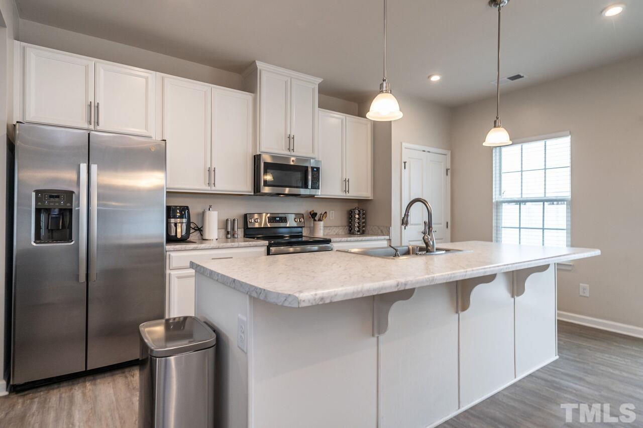 8701 Red Canyon Way Raleigh, NC 27616 - Photo 19 of 28 a kitchen with stainless steel appliances a sink refrigerator and microwave