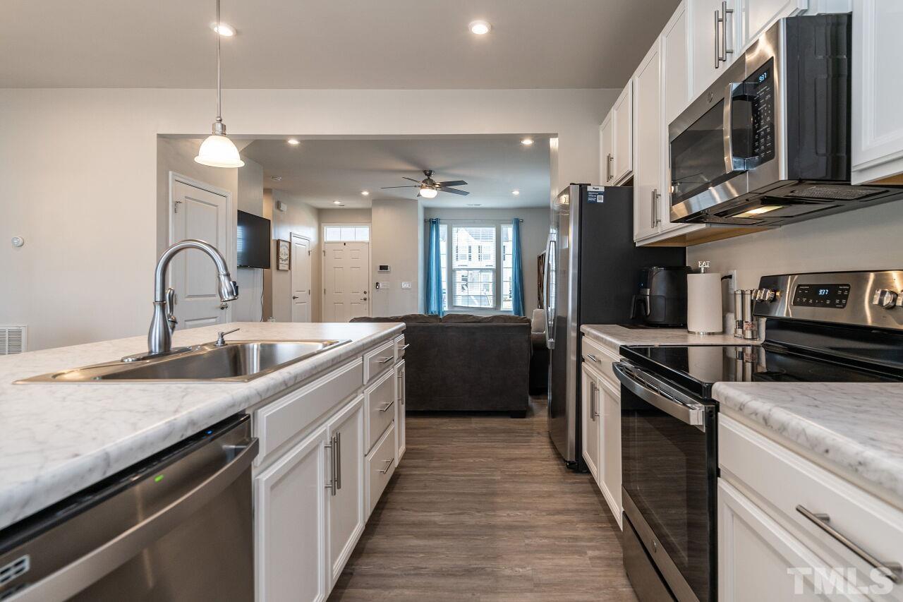 8701 Red Canyon Way Raleigh, NC 27616 - Photo 21 of 28 a kitchen with stainless steel appliances granite countertop a sink a stove top oven and refrigerator