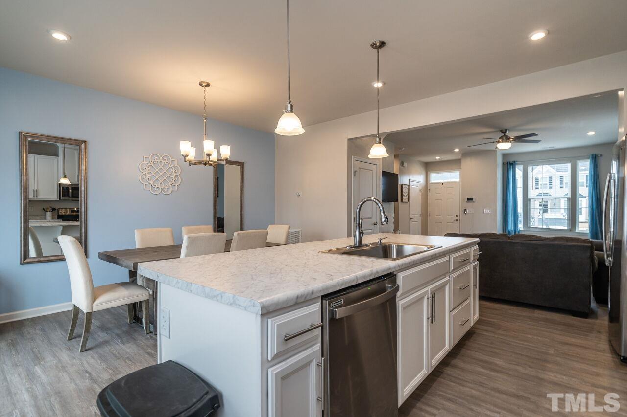 8701 Red Canyon Way Raleigh, NC 27616 - Photo 22 of 28 a large kitchen with kitchen island a sink a stove a dining table and chairs