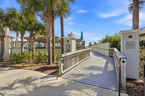a wooden deck with a yard and palm trees