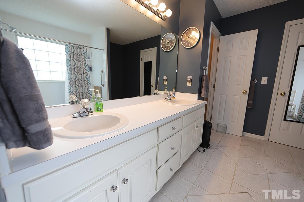 112 Dullis Circle Garner, NC 27529 - Photo 15 of 23 a spacious bathroom with double vanity and a mirror
