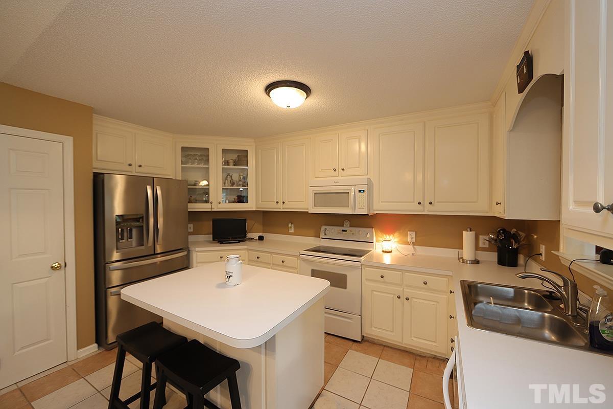 112 Dullis Circle Garner, NC 27529 - Photo 7 of 23 a kitchen with a sink a stove a refrigerator and white cabinets