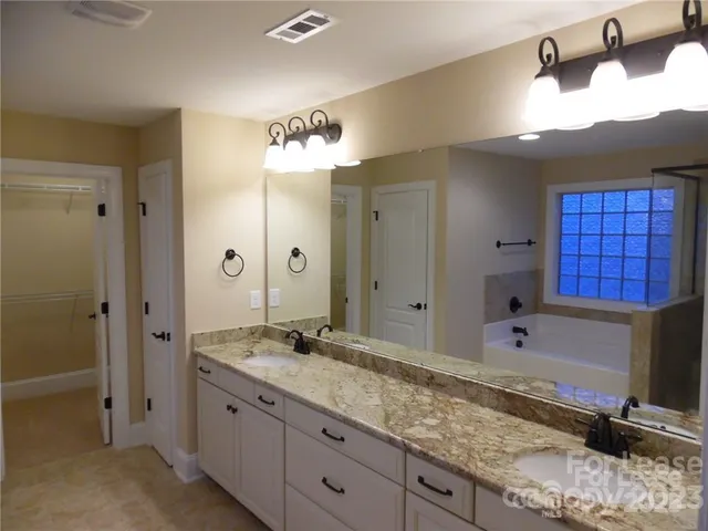 a bathroom with a granite countertop sink a mirror and a shower