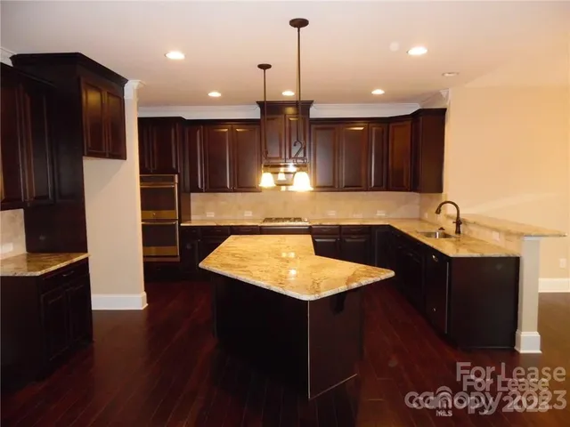 a kitchen with stainless steel appliances granite countertop a sink refrigerator and cabinets