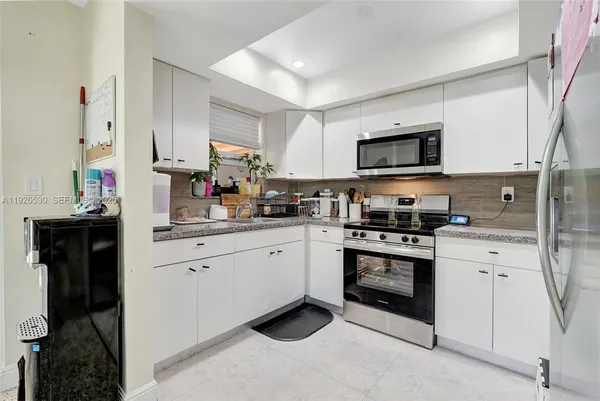 a kitchen with granite countertop cabinets stainless steel appliances and a counter space