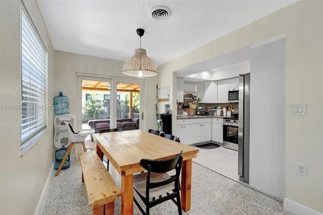 a kitchen with a dining table chairs stainless steel appliances and cabinets
