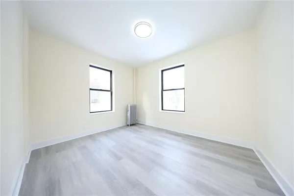 an empty room with windows and closet