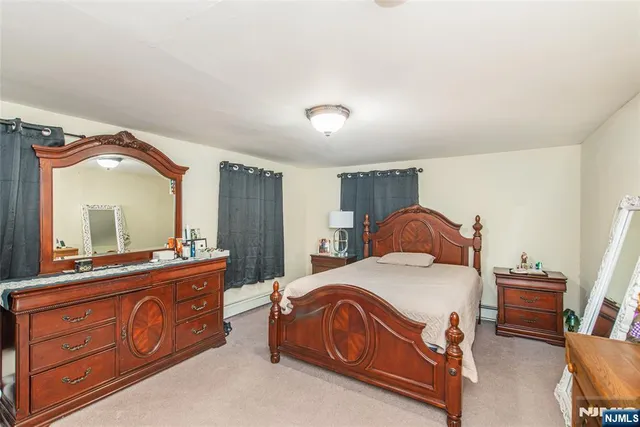 a bedroom with a bed and a bathroom with mirror