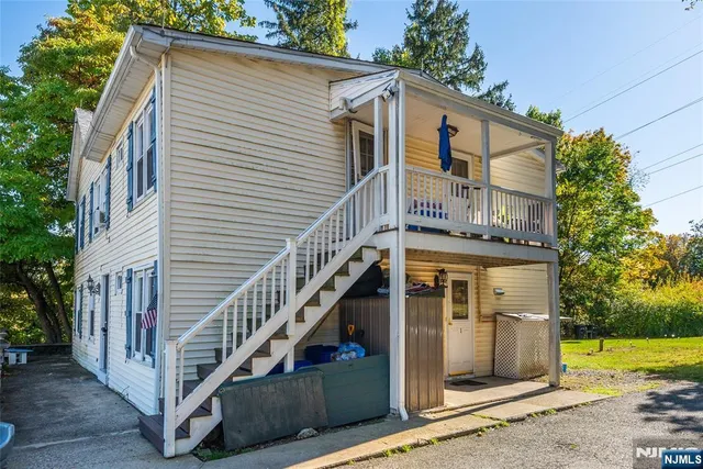 a view of a house with a yard and potted plants