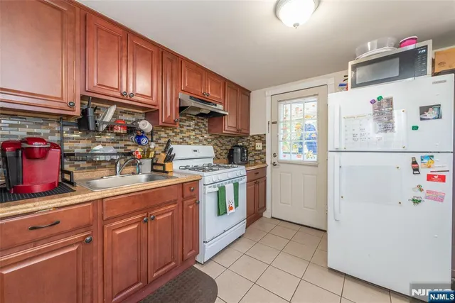 a kitchen with a refrigerator sink and cabinets