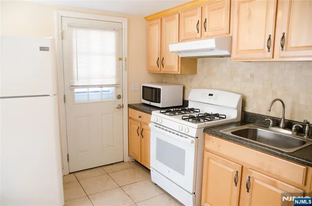 a kitchen with a stove cabinets and a refrigerator