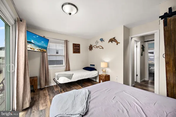 a bedroom with a bed and a refrigerator