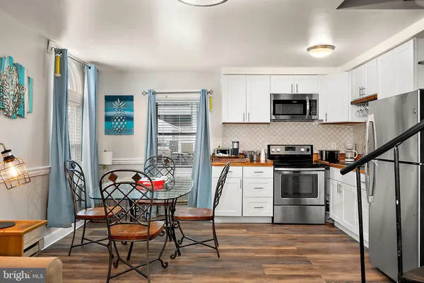 a kitchen with stainless steel appliances kitchen island granite countertop a refrigerator and microwave