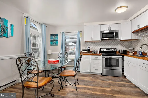 a kitchen with stainless steel appliances kitchen island granite countertop a stove top oven a sink a table and chairs