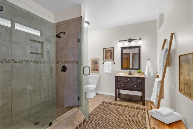 a bathroom with a shower a sink and a mirror