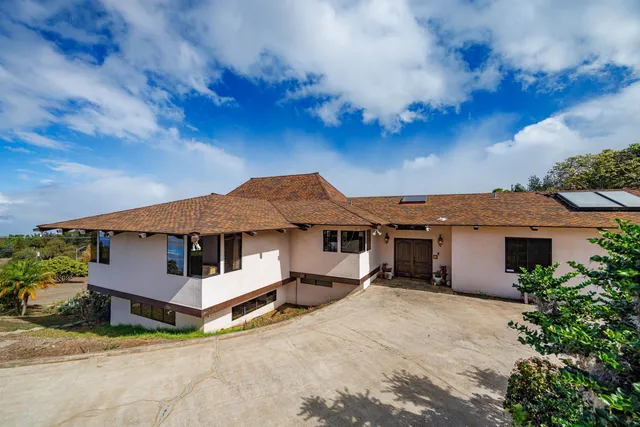 a view of a white house with a big yard and large tree