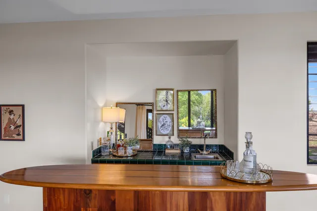 a living room with furniture a large window and wooden floor