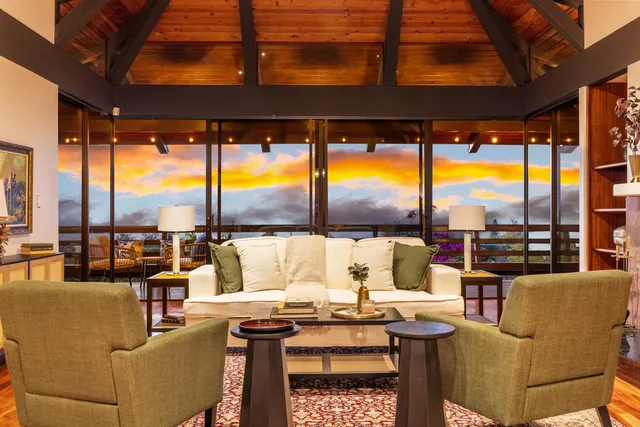 a living room with furniture a floor to ceiling window and an outdoor view