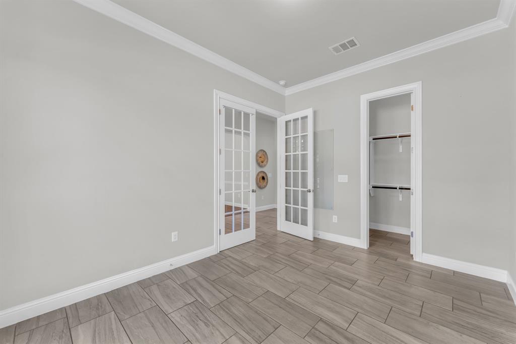 110 Magona Trail Georgetown, TX 78628 - Photo 10 of 38 French doors open into a versatile space with wood-look tile flooring.
