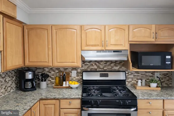 a kitchen with granite countertop stainless steel appliances stove top oven and cabinets