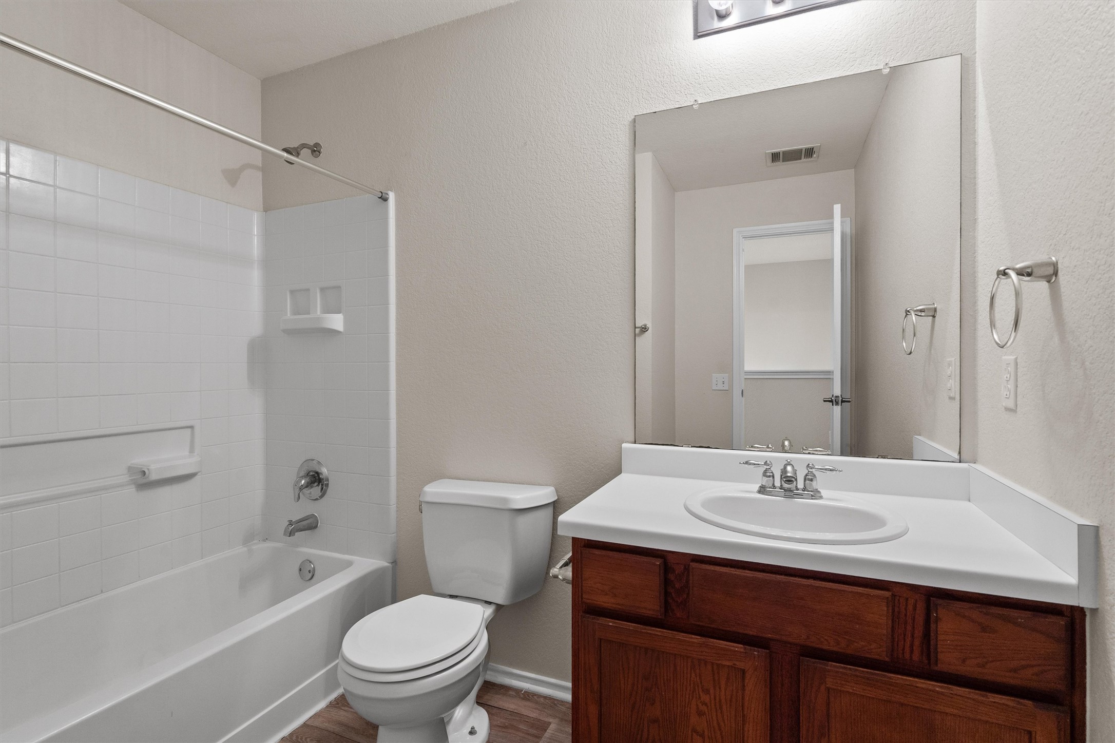 5825 Silver Screen Drive Austin, TX 78747 - Photo 24 of 40 A well-appointed bathroom features a single vanity, a standard tub, and rich wood cabinetry.