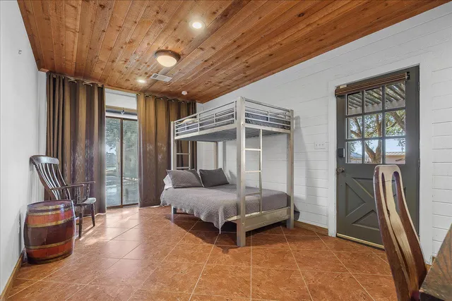 a spacious bedroom with a bed and glass door