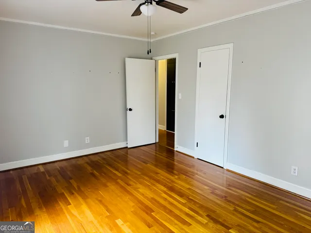 a view of an empty room with ceiling fan